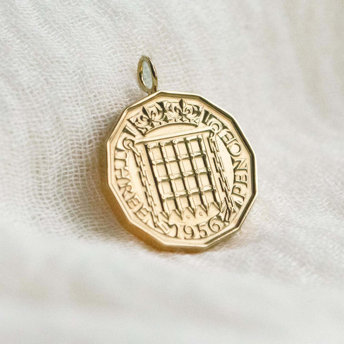 22ct Gold pendant on a textured white fabric background