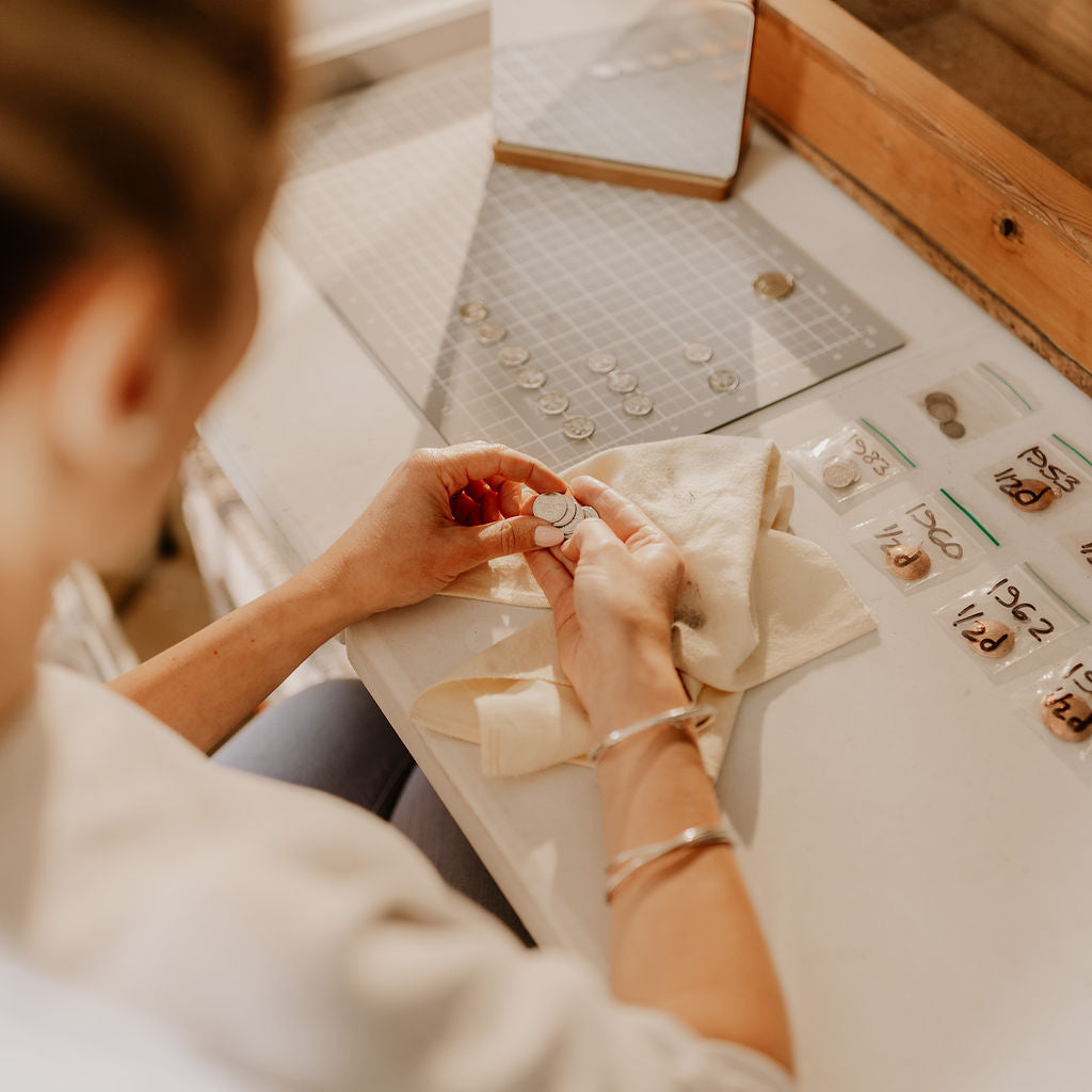 Person working with jewelry in a workshop setting
