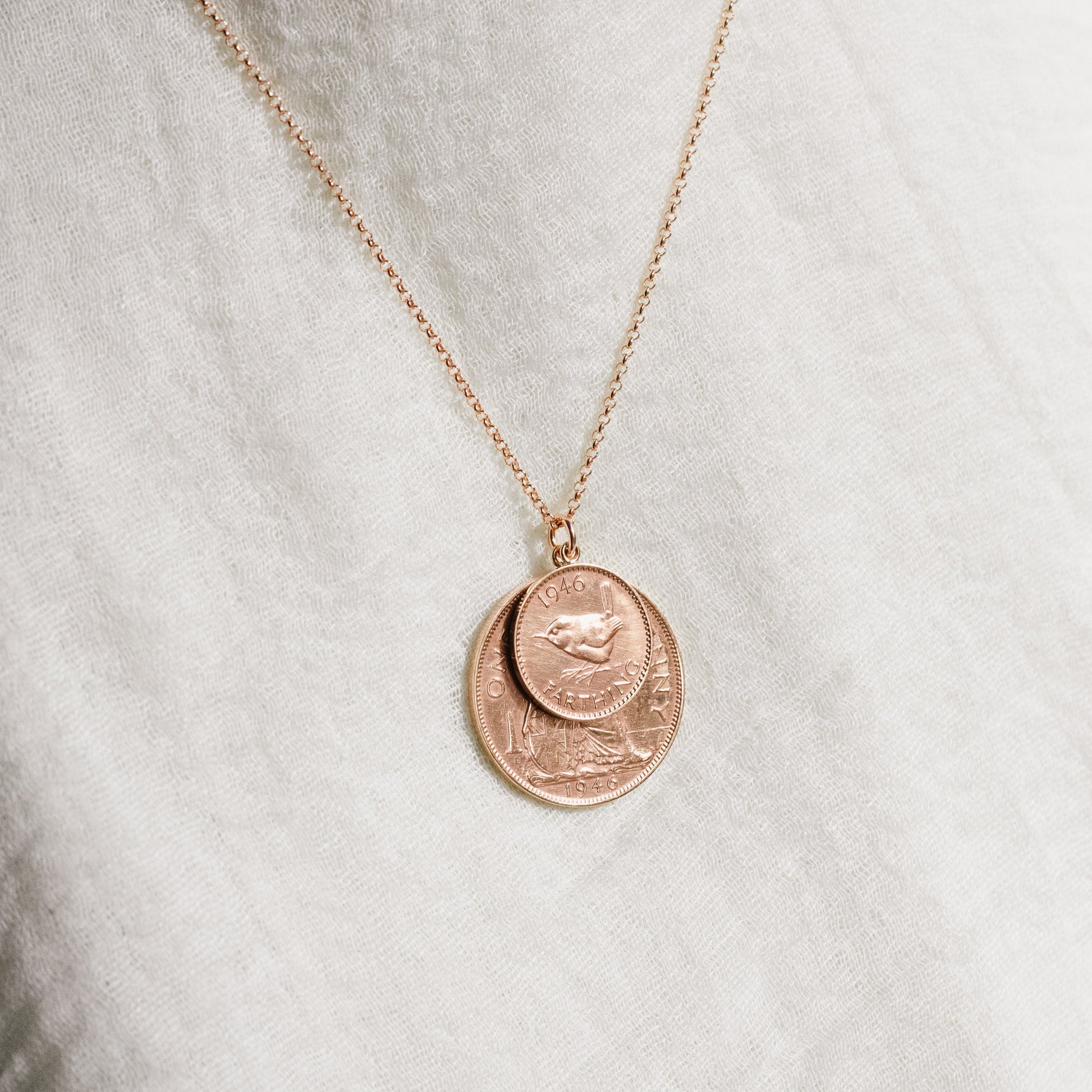 Rose gold double coin necklace with penny and farthing coins on a white background with rose vermeil chain