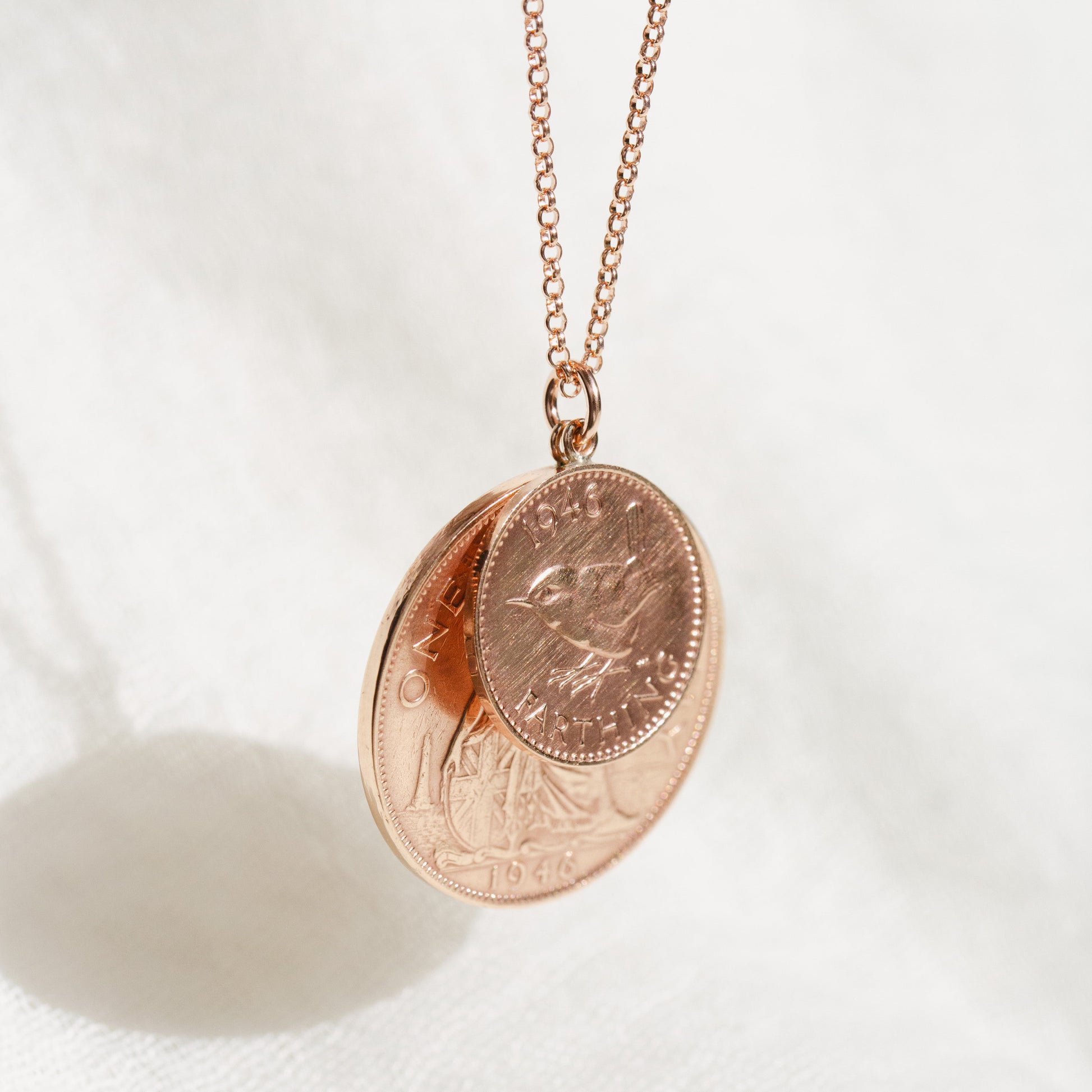 Rose gold necklace with a two coin pendant on a white background