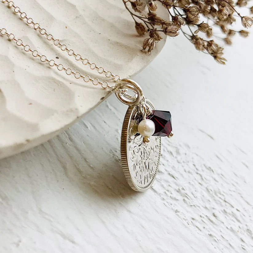 Sterling silver soldered bail on a 1954 sixpence pendant with garnet crystal charm and freshwater pearl. Made in Stamford UK