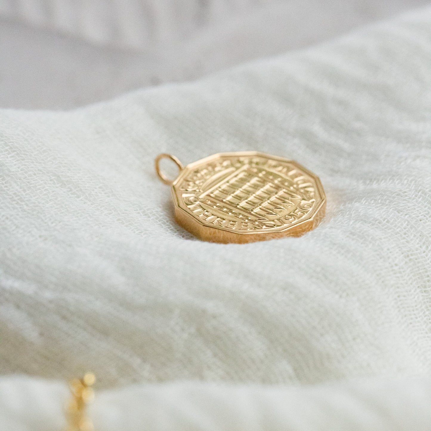 Gold coin pendant lying on a white cloth with real British coin |Coin Jewellery handcrafted in Stamford UK - Prenoa