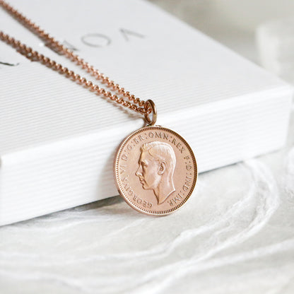 Rose gold necklace with a pendant on a white surface