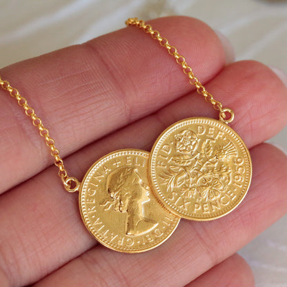 Double sixpence necklace sits on a hand for scale. Sixpences drenched in 22ct gold and soldered together making a contemporary double heads and tails design.