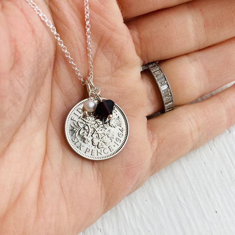 Sixpence 1964 necklace being held in the hand for scale
