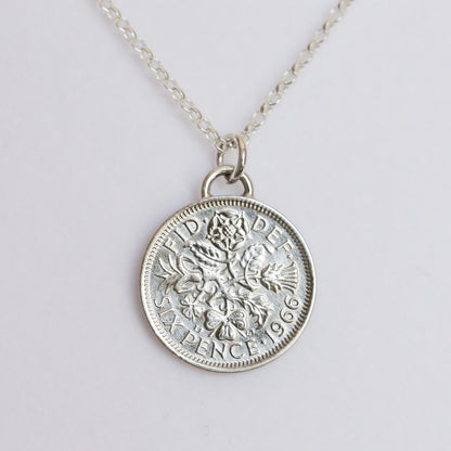 Silver silver coin pendant necklace with a signature arc bail on a light gray background