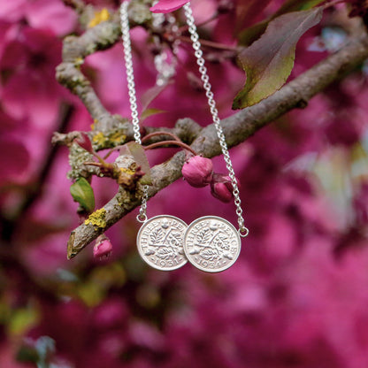 Silver threepence double coin necklace with circular pendants on a branch with pink flowers. Each threepence coin is soldered to the next, making the design reversible and easy to style with other necklaces.