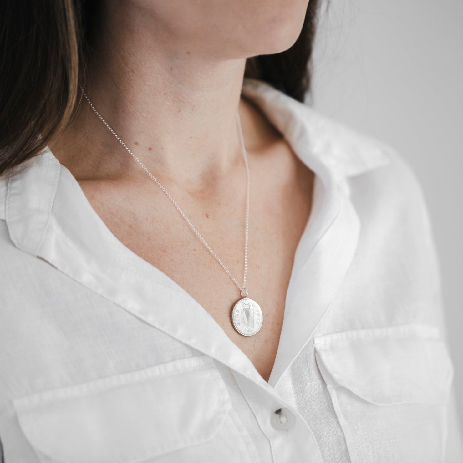 Model wears a Celtic coin necklace with sterling silver 