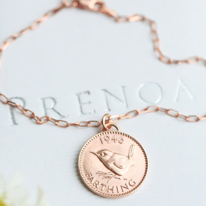 Rose gold coin necklace on a white box with a real Jenny Wren farthing and rose gold vermeil fine paperclip chain. 