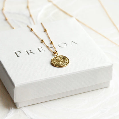 Gold necklace with a pendant on a white box with 'PRELOVED' branding.