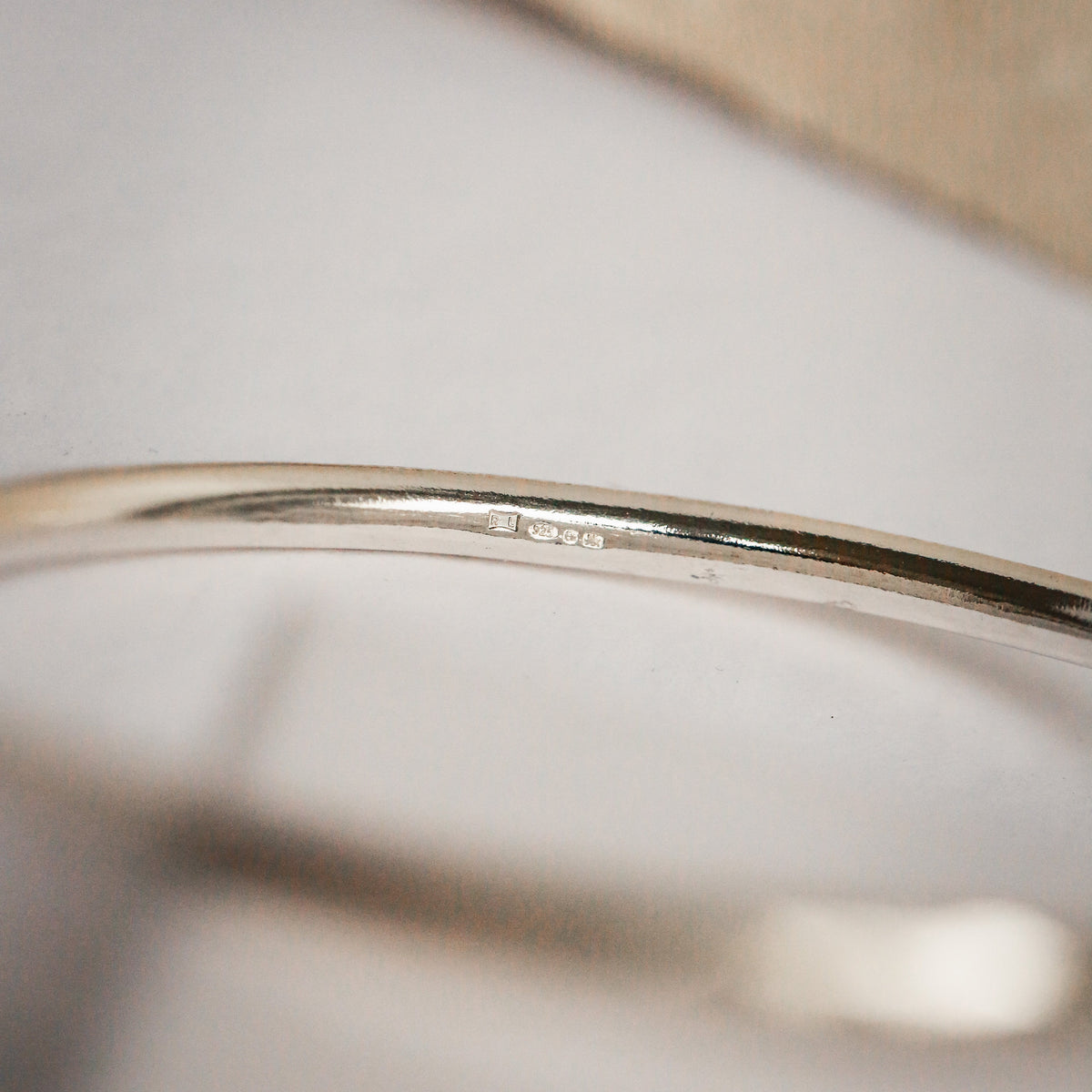 Close-up of a silver bracelet on a neutral background
