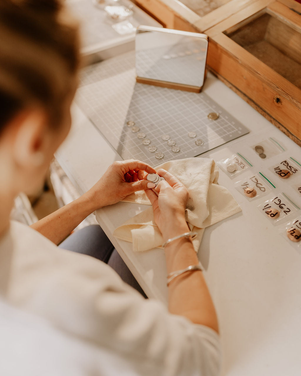 Person working with jewelry in a workshop setting