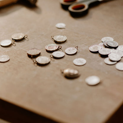 Jewelry-making tools and components on a wooden surface