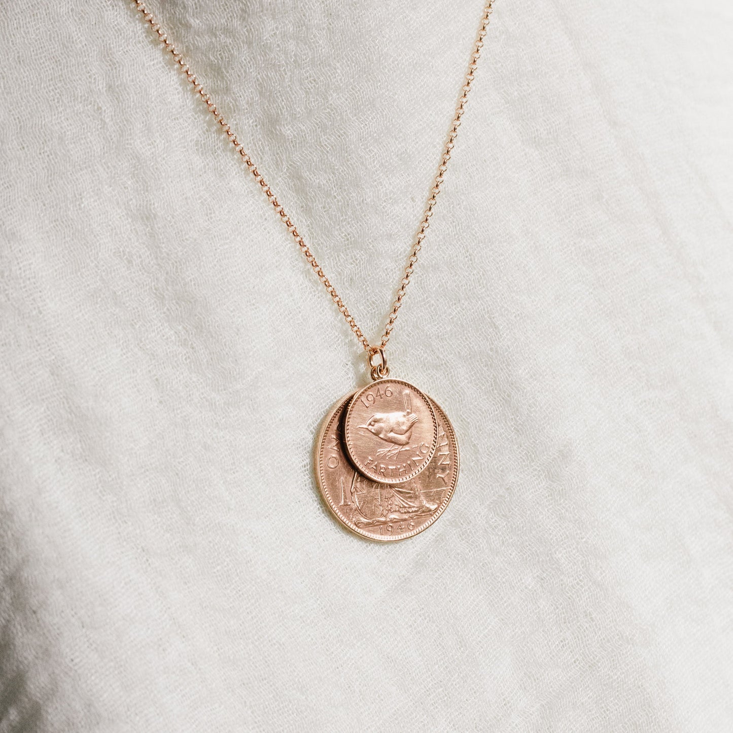 Rose gold double coin necklace with penny and farthing coins on a white background with rose vermeil chain