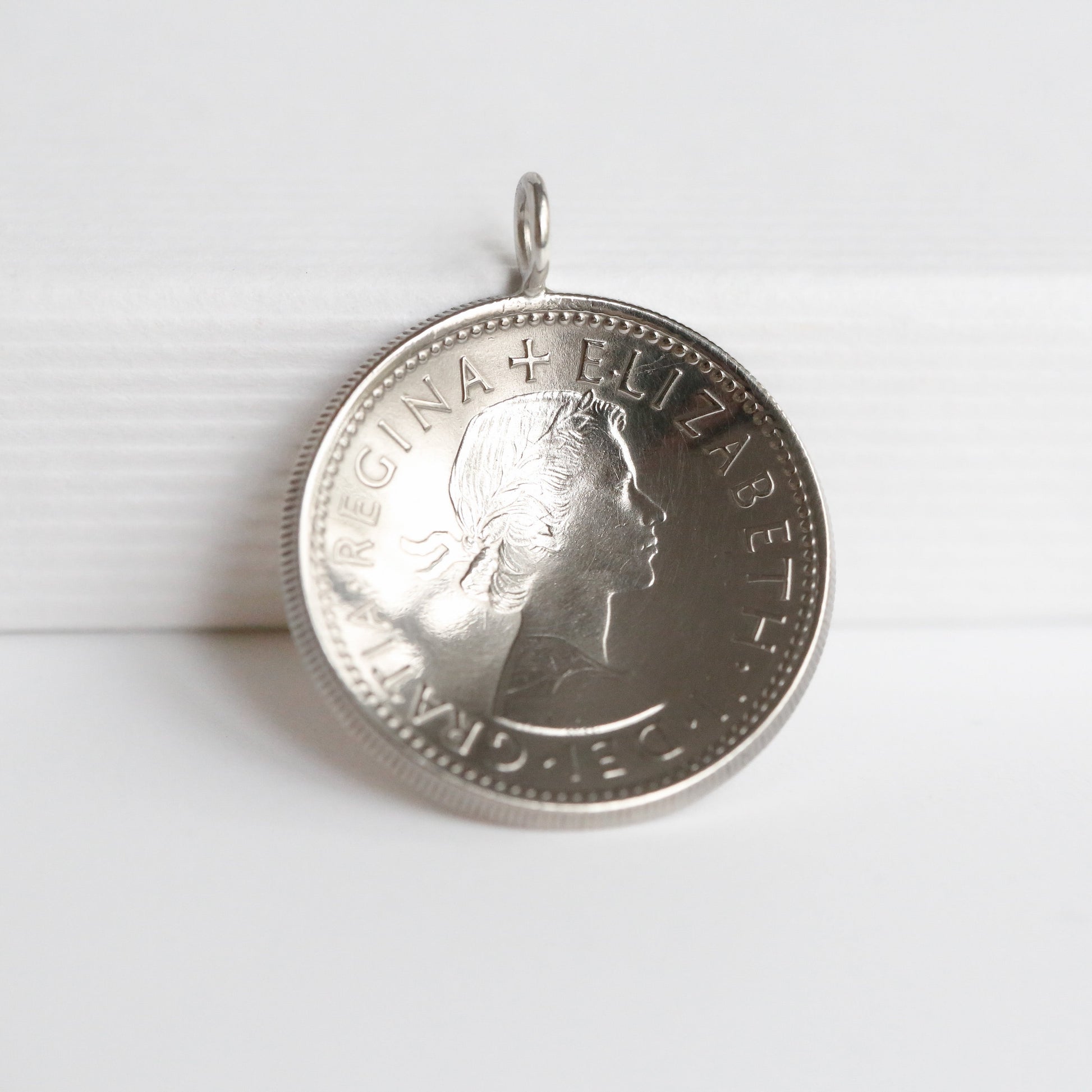1966 Queen Elizabeth II domed shilling coin pendant on a white background