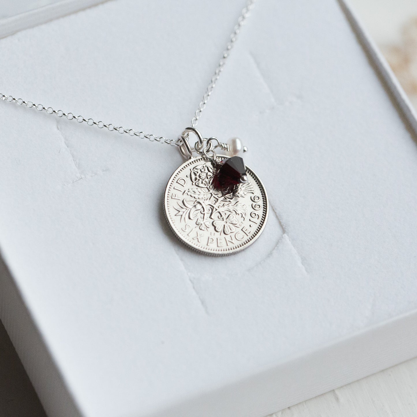 Silver sixpence vintage coin necklace with a pendant on a white box