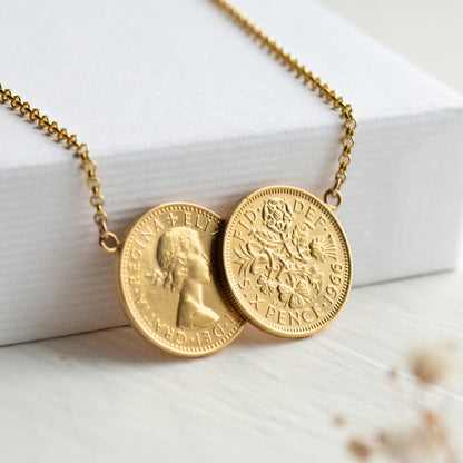 Gold double sixpence  1966 dated necklace with coin pendants on a white surface.