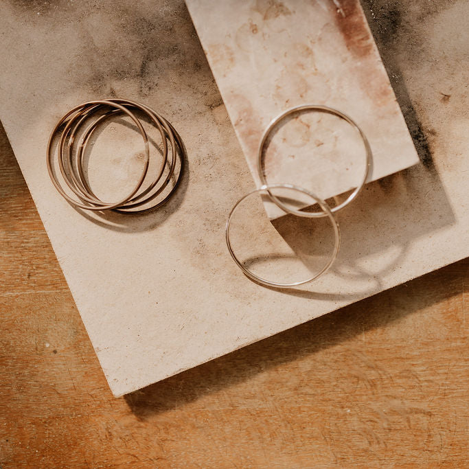 Sterling silver bangles on solde3ring blocks and workbench and natural lighting.