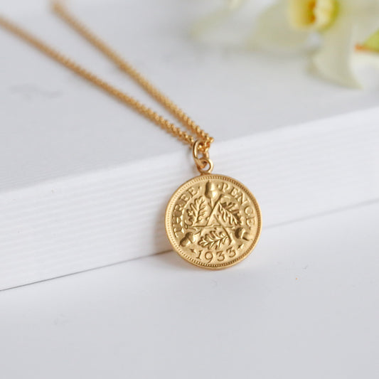 Real British gold coin necklace with 22carat gold plating. 1933 date. Gold vermeil precious metal chain on a white background.