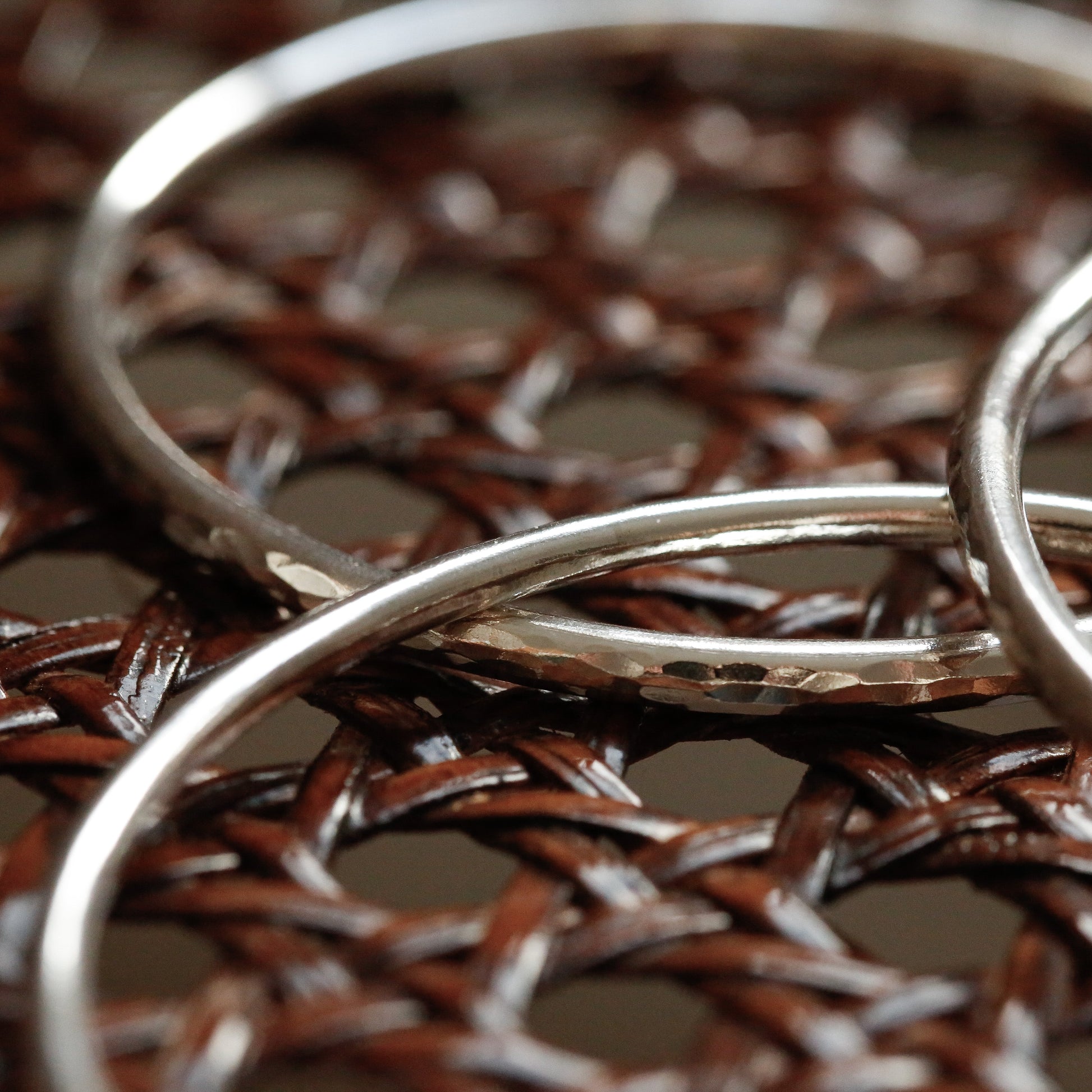 Close-up of silver rings on a textured brown surface