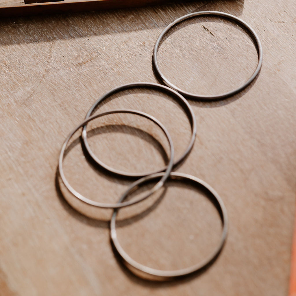 Silver bangles on a wooden surface