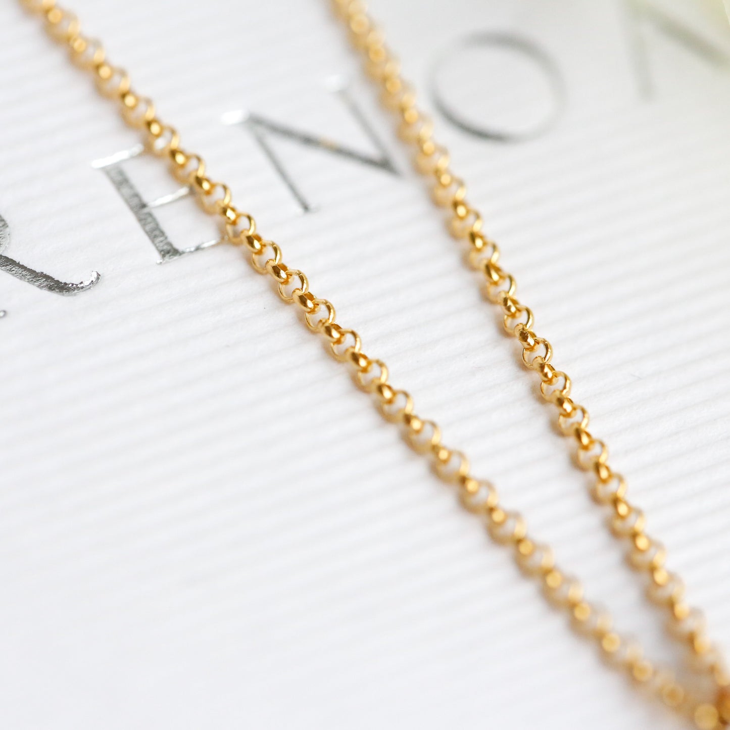 Gold chain necklace on a blurred background with text