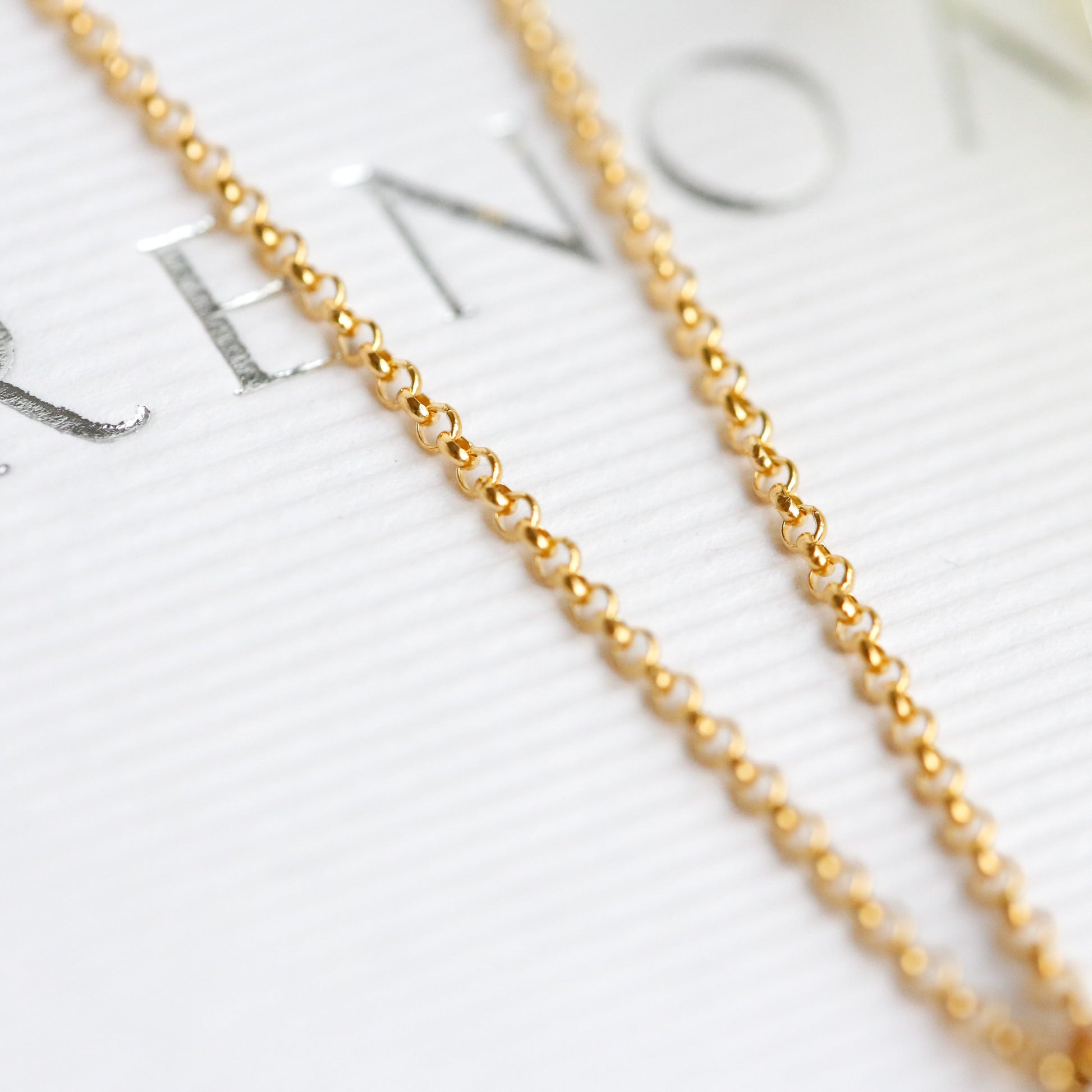 Gold chain necklace on a blurred background with text