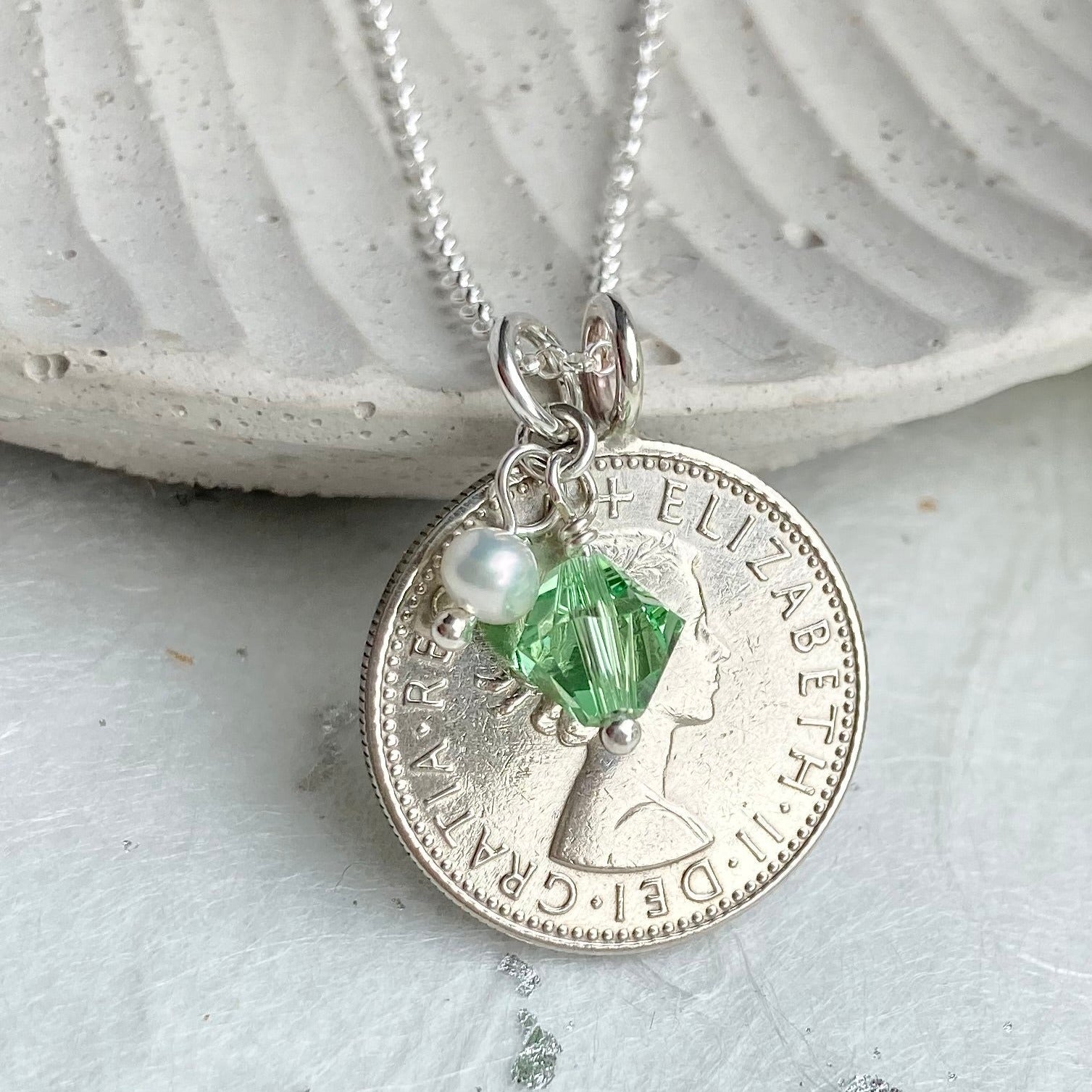 Sixpence necklace showing Queen Elizabeth and a peridot August charm